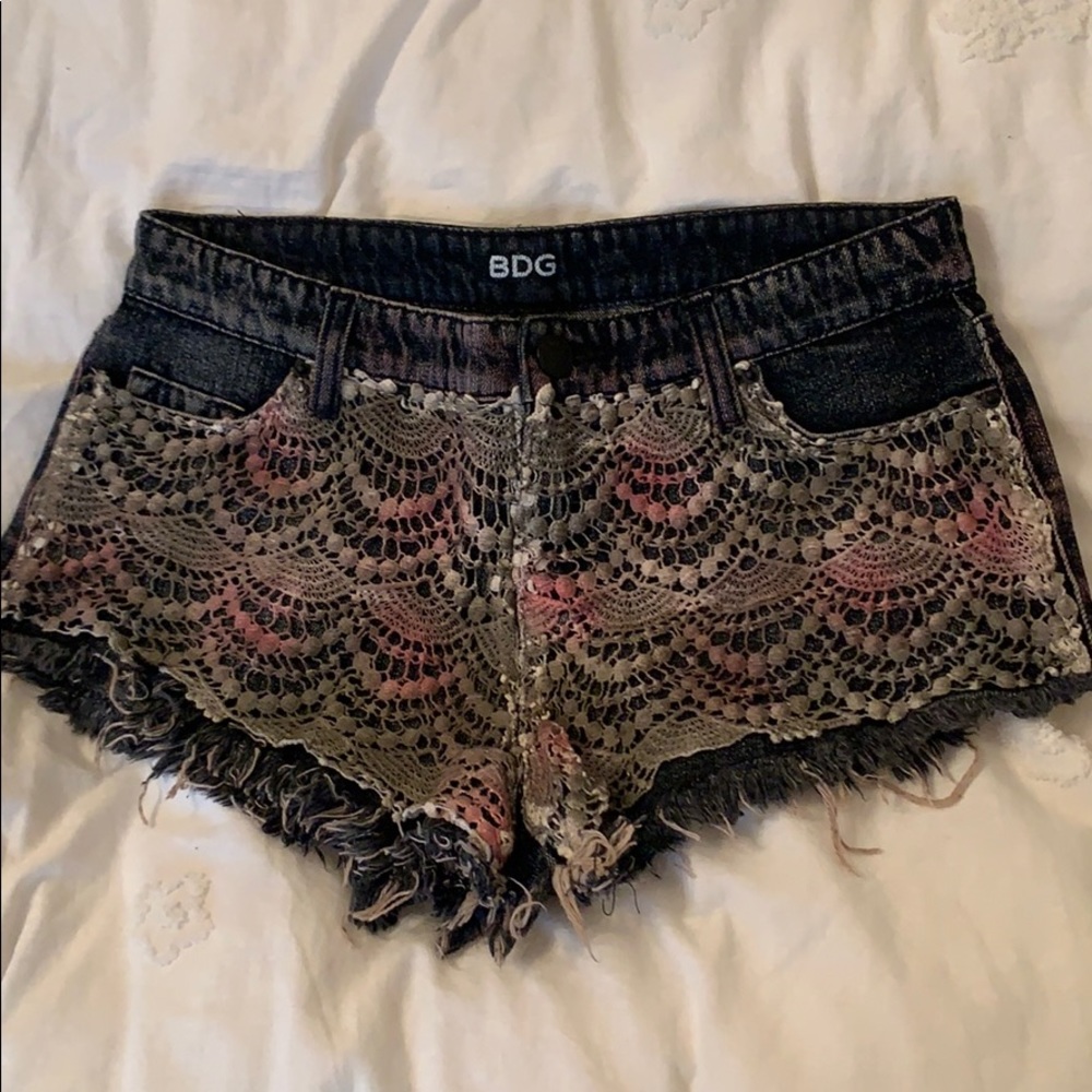 Black denim shorts with crochet overlay.